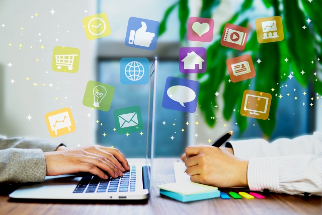 パソコン作業とデジタルアイコンのイメージ