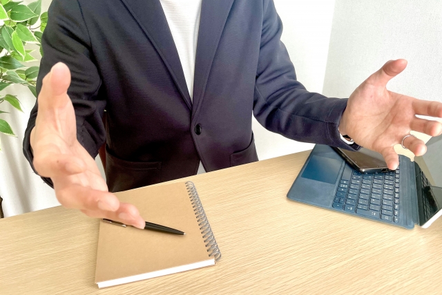 両手を開いて話すビジネスマン