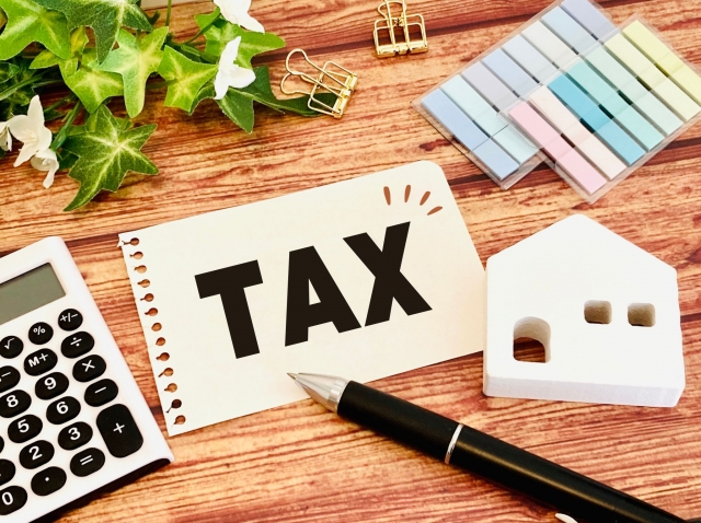 TAXと書かれた紙と住宅の模型