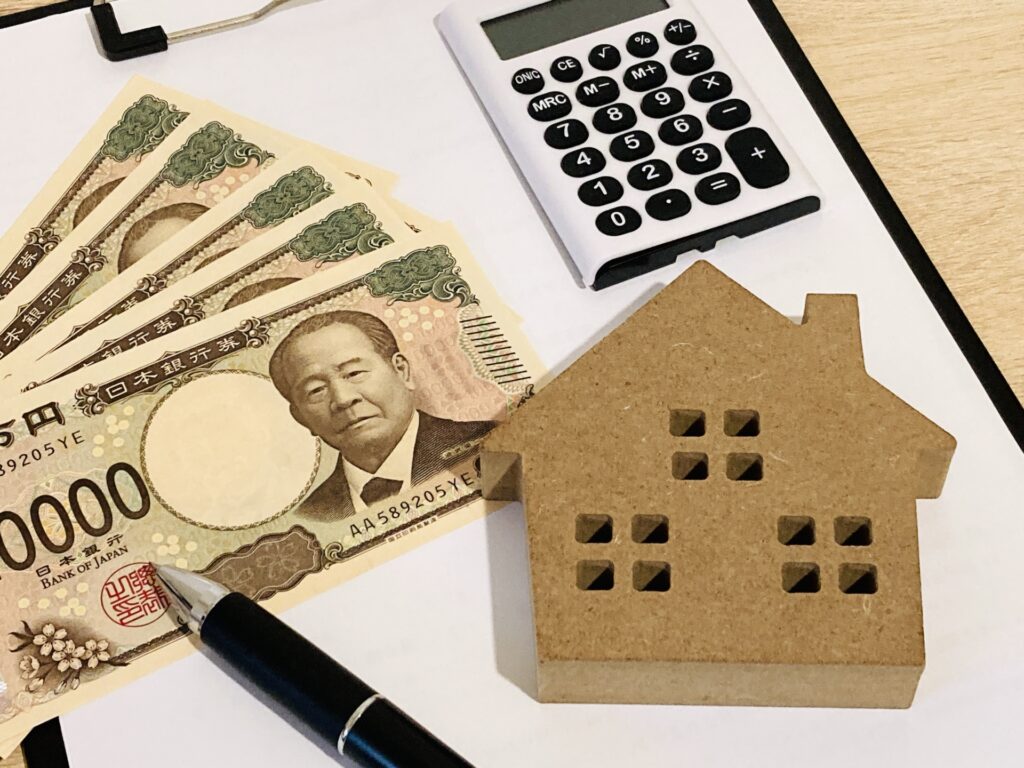 現金と電卓・住宅模型による不動産資金のイメージ