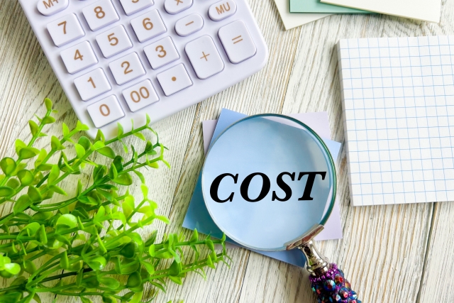 COSTと書かれた虫眼鏡と電卓のイメージ