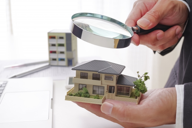住宅模型を虫眼鏡で確認するイメージ