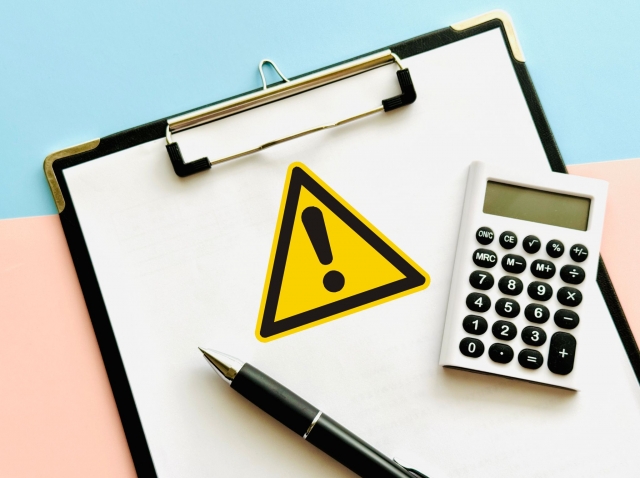 注意マークと電卓・クリップボードのイメージ